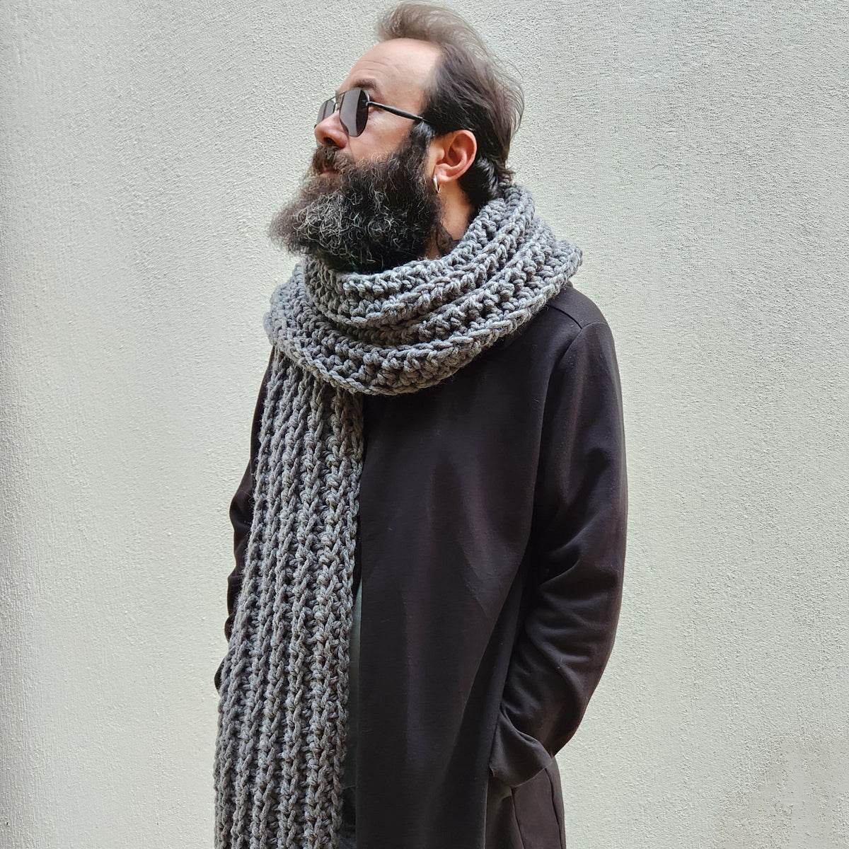Person wearing a long, thick gray scarf 